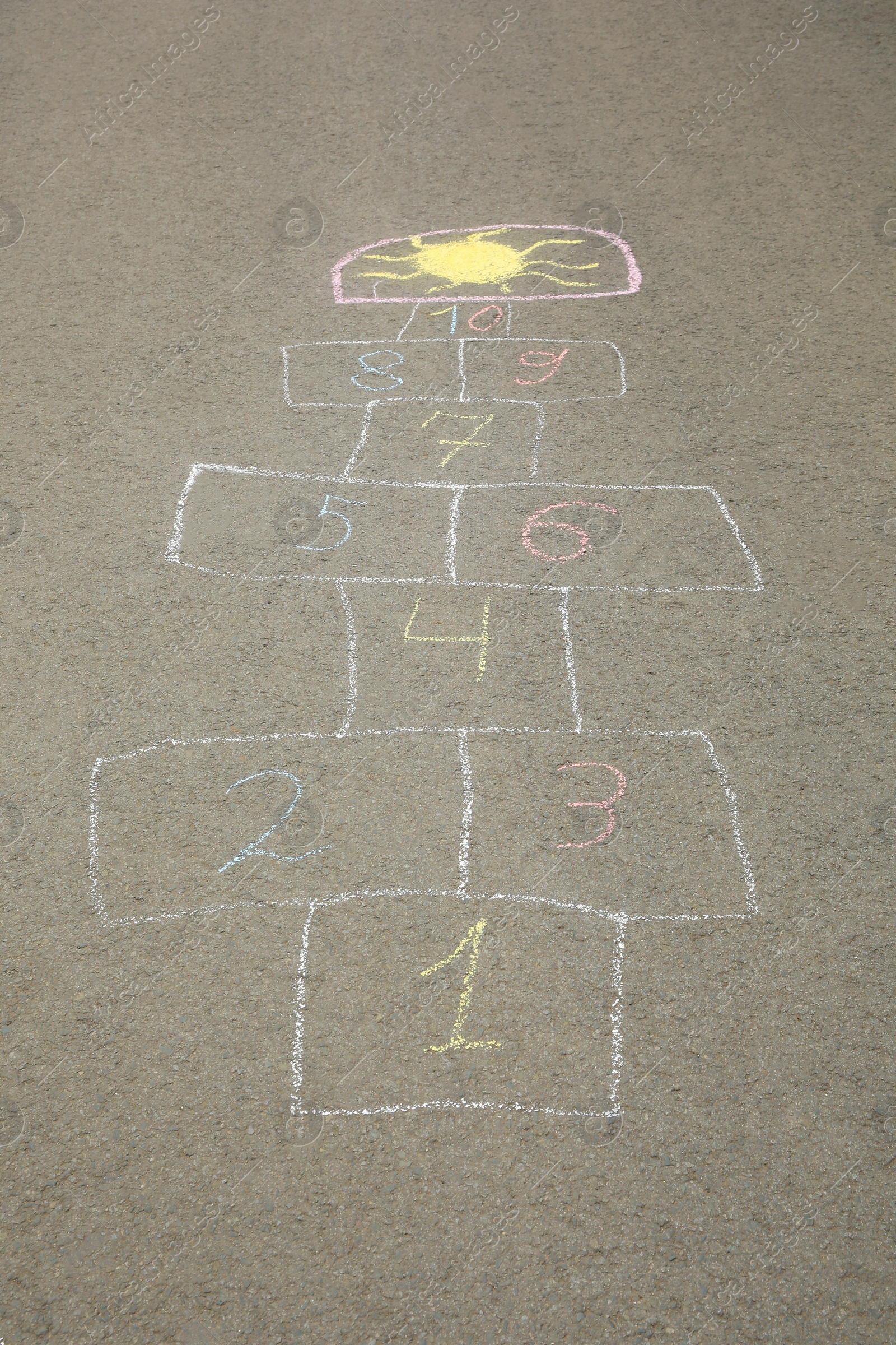 Photo of Hopscotch drawn with colorful chalk on asphalt outdoors