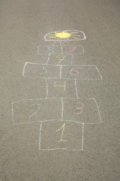 Hopscotch drawn with colorful chalk on asphalt outdoors