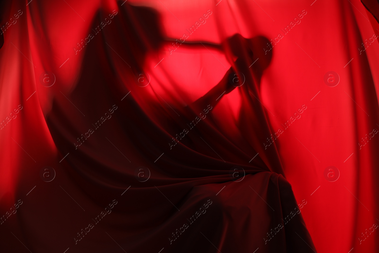 Photo of Silhouette of creepy ghost behind red cloth