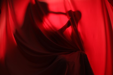 Silhouette of creepy ghost behind red cloth