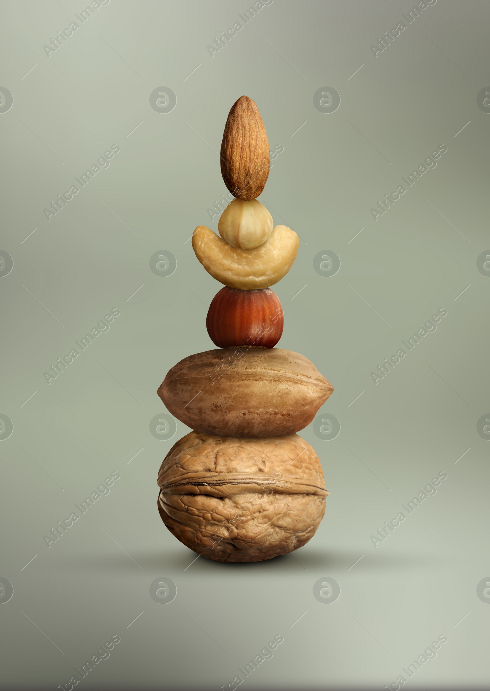 Image of Stacked different nuts on grey gradient background