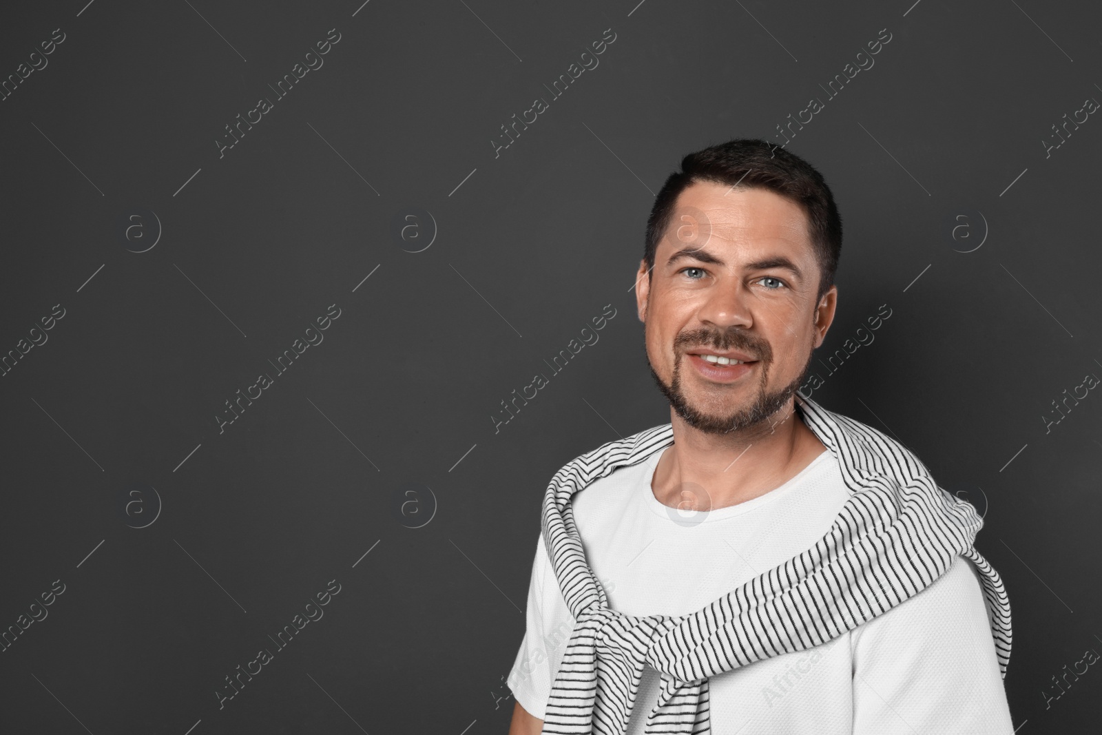 Photo of Portrait of handsome man on dark background. Space for text