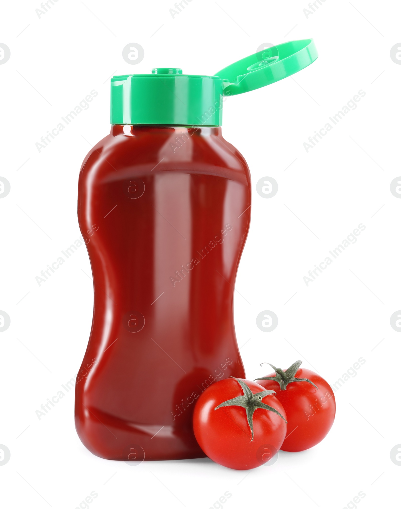 Photo of Bottle of tasty ketchup and fresh tomatoes isolated on white