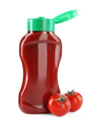 Photo of Bottle of tasty ketchup and fresh tomatoes isolated on white