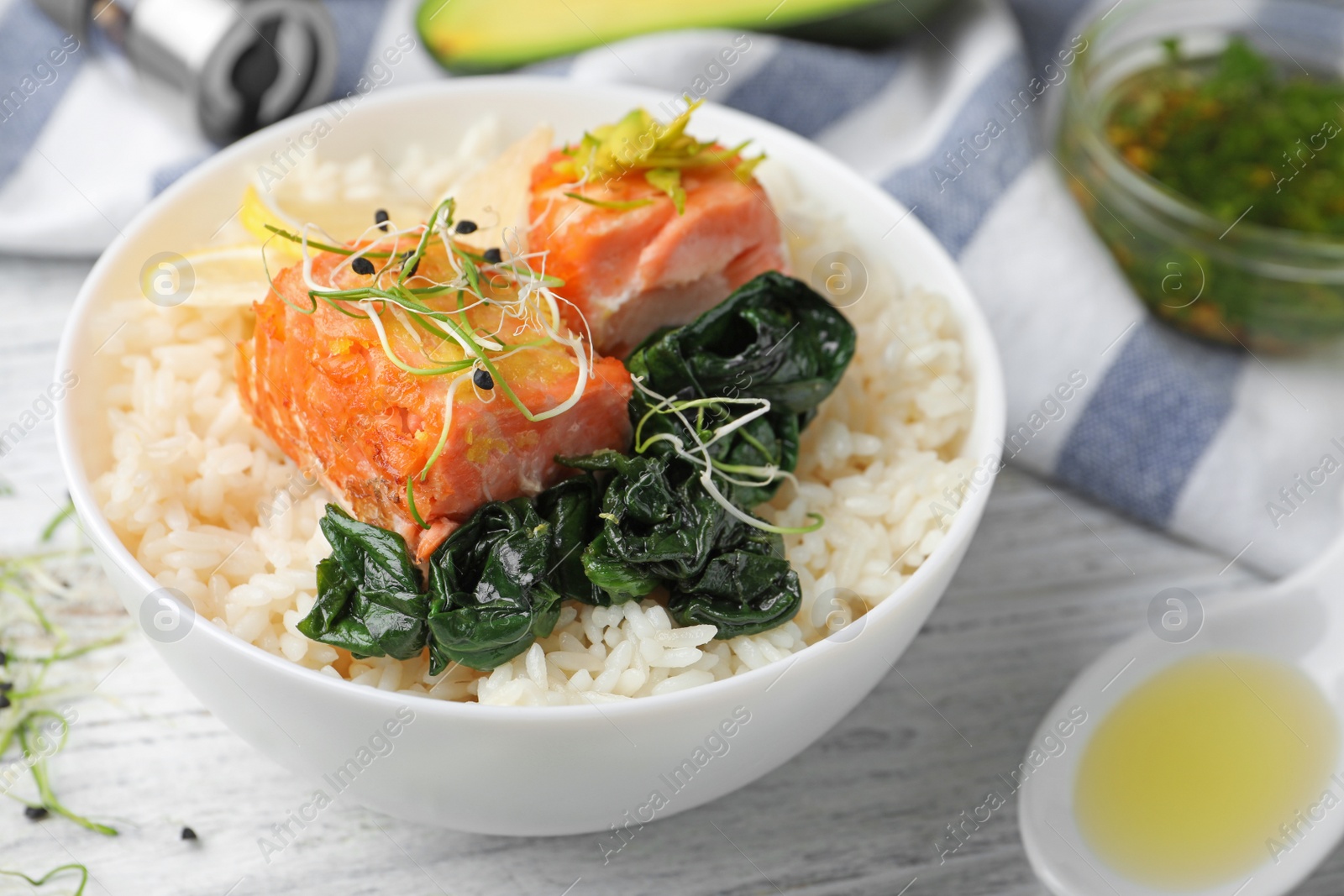 Photo of Tasty salmon with rice and spinach on white wooden table