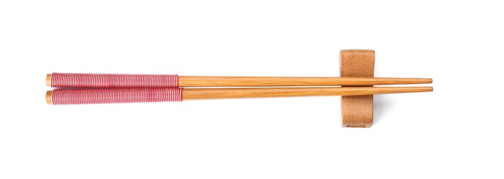 Photo of Pair of wooden chopsticks with rest isolated on white, top view