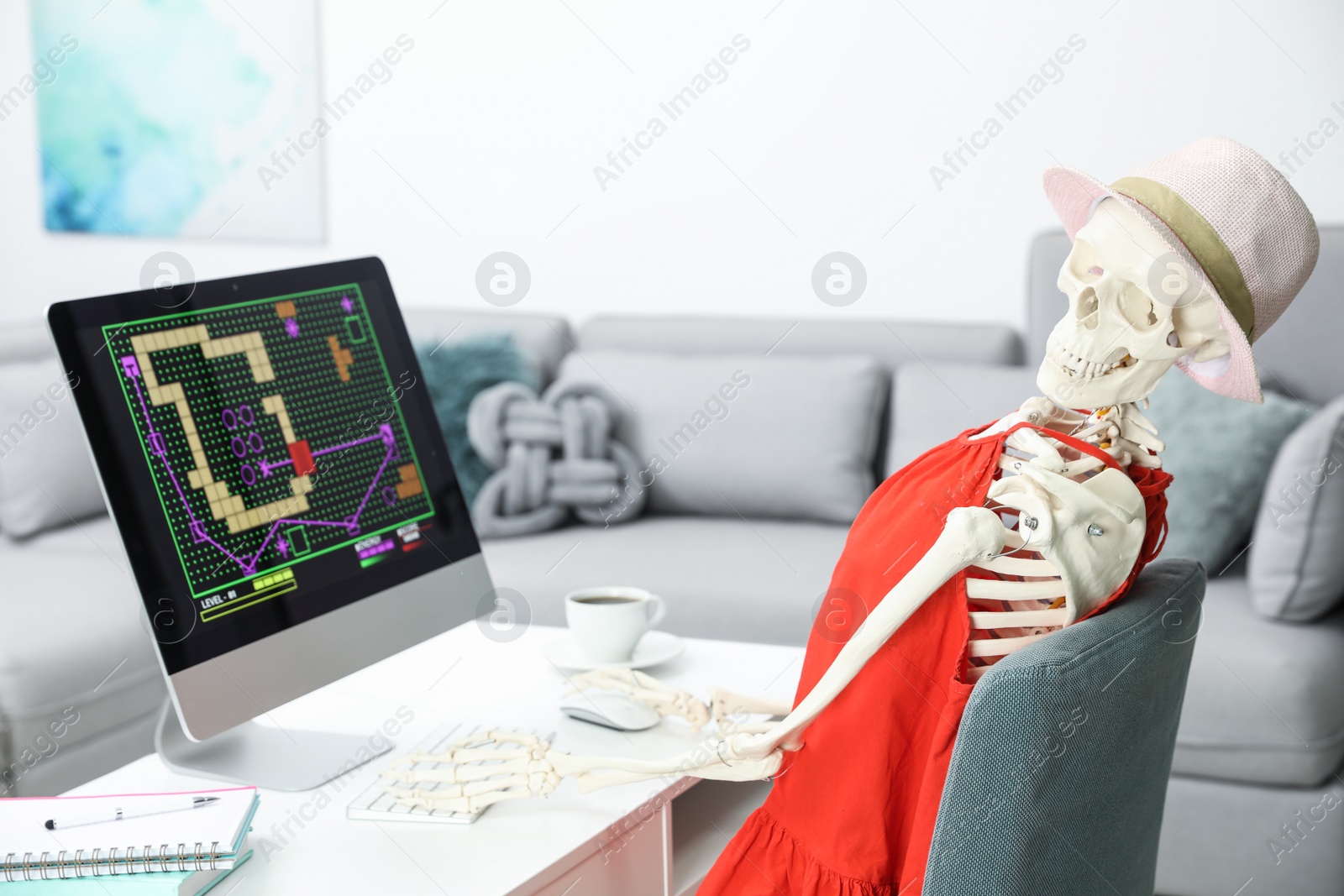 Photo of Human skeleton in red dress playing game at home