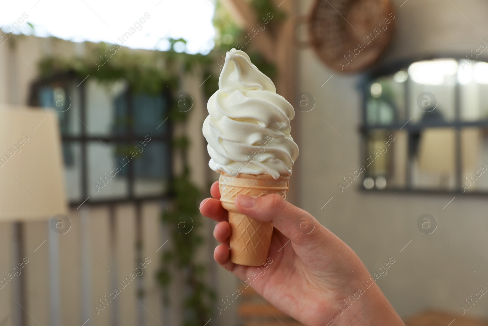Photo of Woman holding delicious ice cream indoors, closeup. Space for text