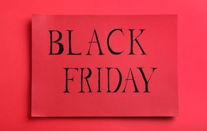 Photo of Card with words Black Friday on red background, top view