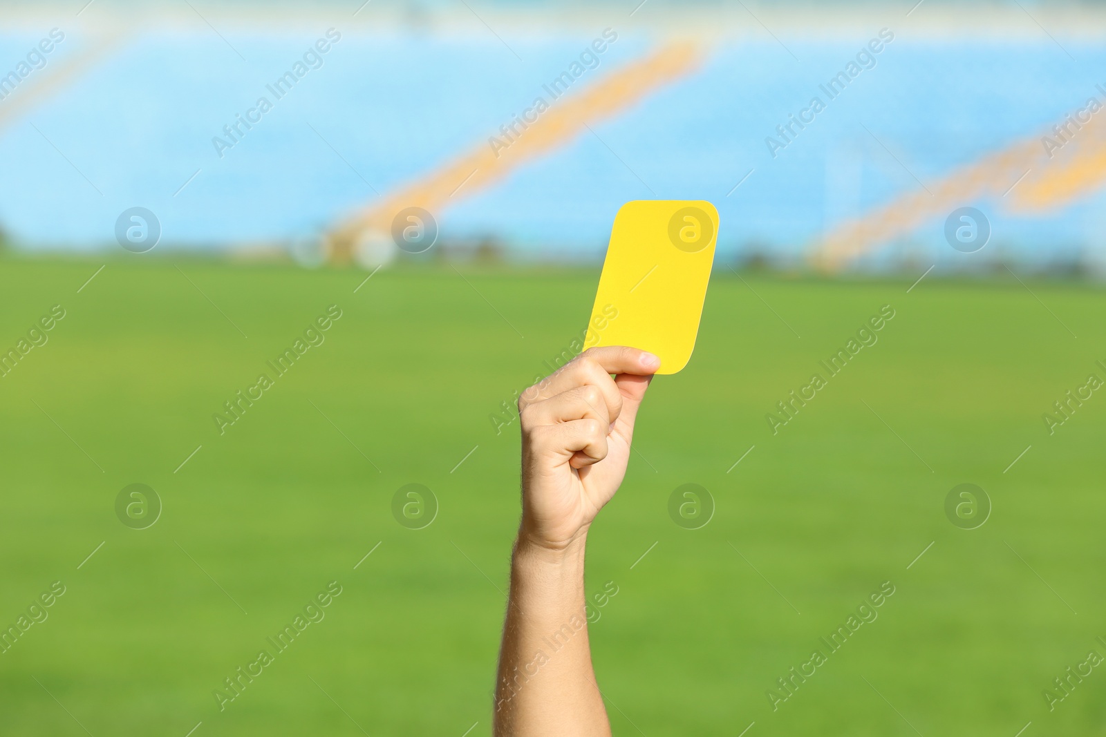 Photo of Football referee showing yellow card at stadium, closeup