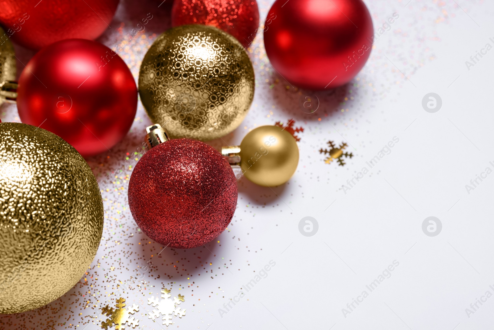 Photo of Christmas balls, confetti and glitter on white background, closeup