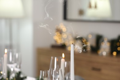 Photo of Extinguished candle and glasses indoors, space for text