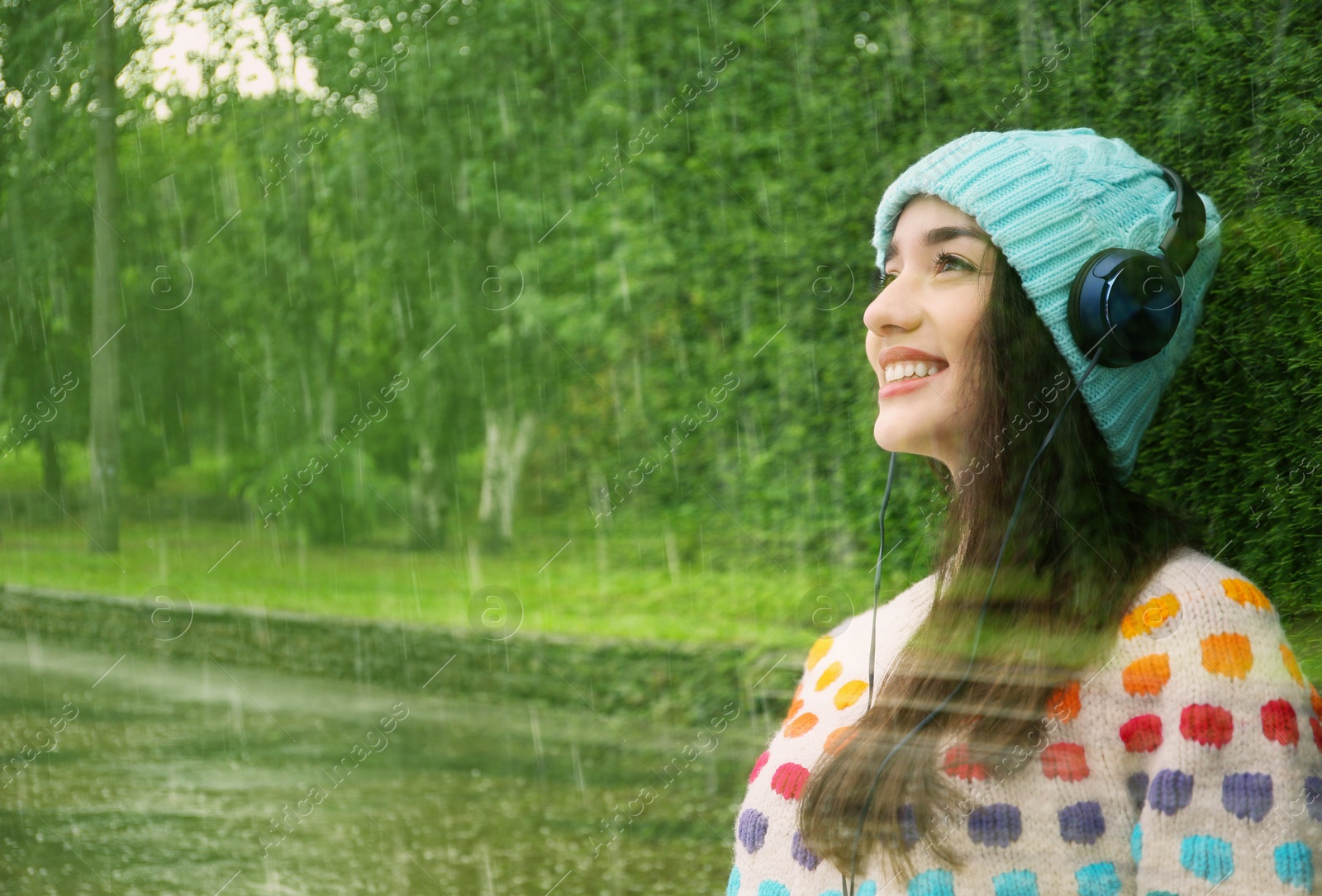 Image of Double exposure of heavy pouring rain in green park and beautiful woman with headphones listening to music