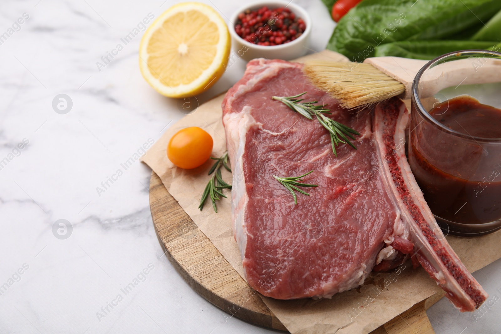 Photo of Raw meat, rosemary, marinade and products on white marble table, closeup. Space for text