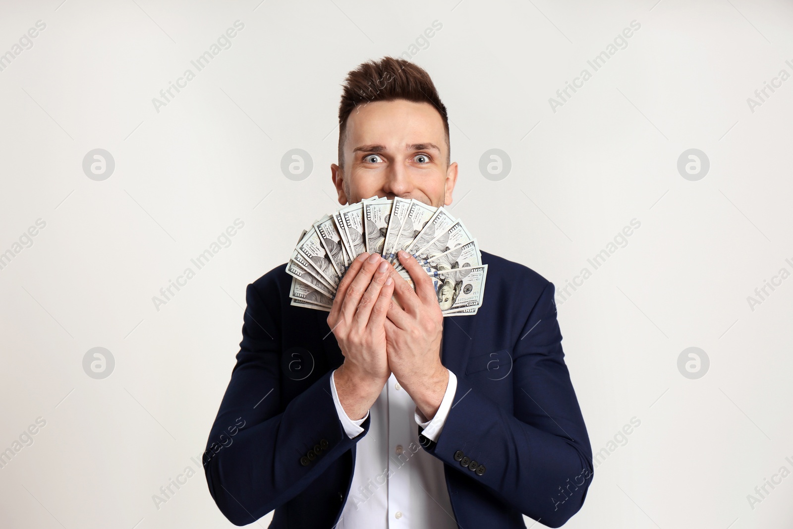 Photo of Happy man with cash money on light grey background