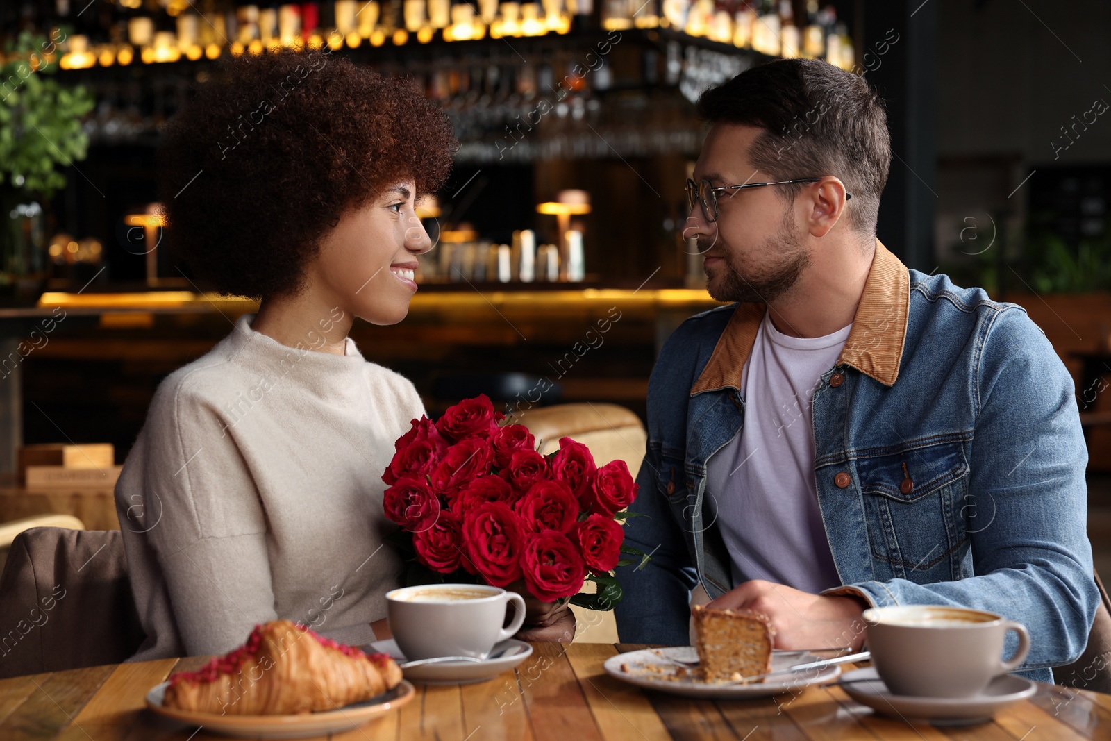 Photo of International relationships. Lovely couple having romantic date in cafe