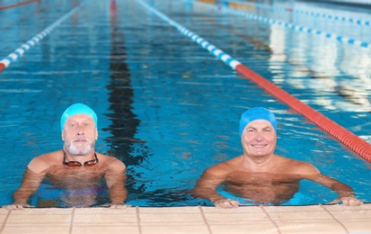 Photo of Sportive senior men in indoor swimming pool