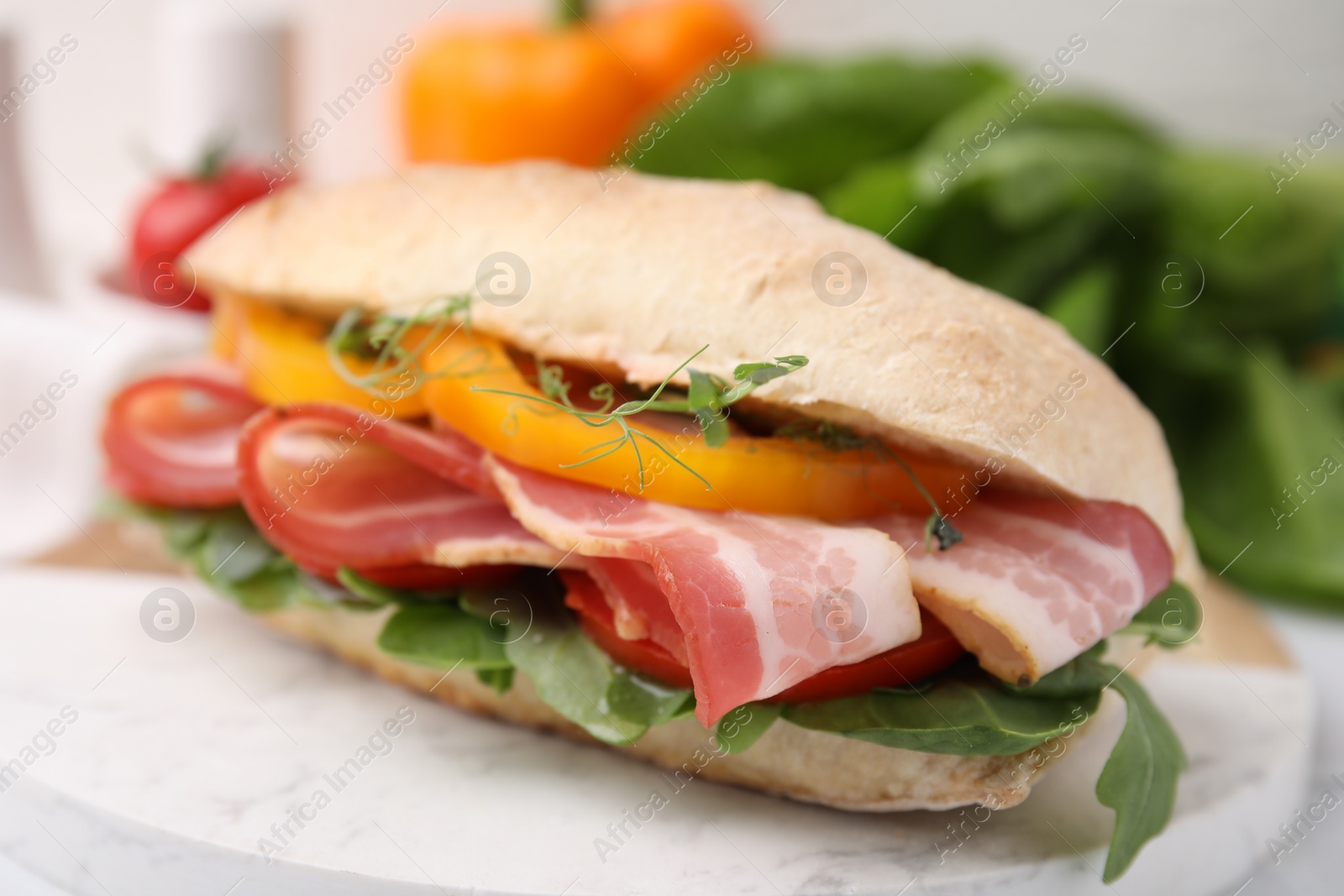 Photo of Tasty sandwich with bacon and bell pepper on white table, closeup