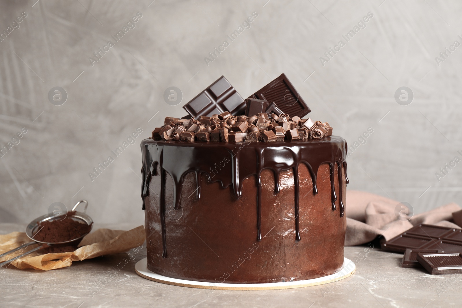 Photo of Freshly made delicious chocolate cake on marble table against grey background