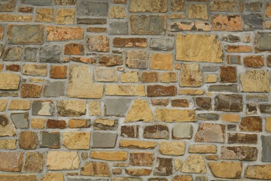 Photo of Beautiful stone wall made of bricks as background, closeup