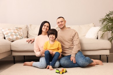 Photo of Happy family sitting on floor at home