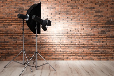 Professional lighting equipment near wall in photo studio. Space for text