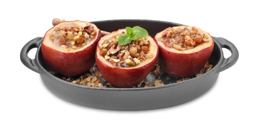 Photo of Tasty baked apples with nuts, honey and mint in baking dish isolated on white