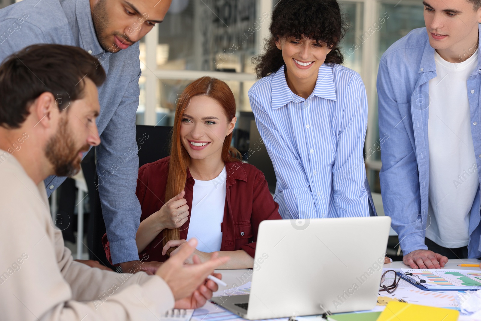 Photo of Team of employees working together at table in office. Startup project