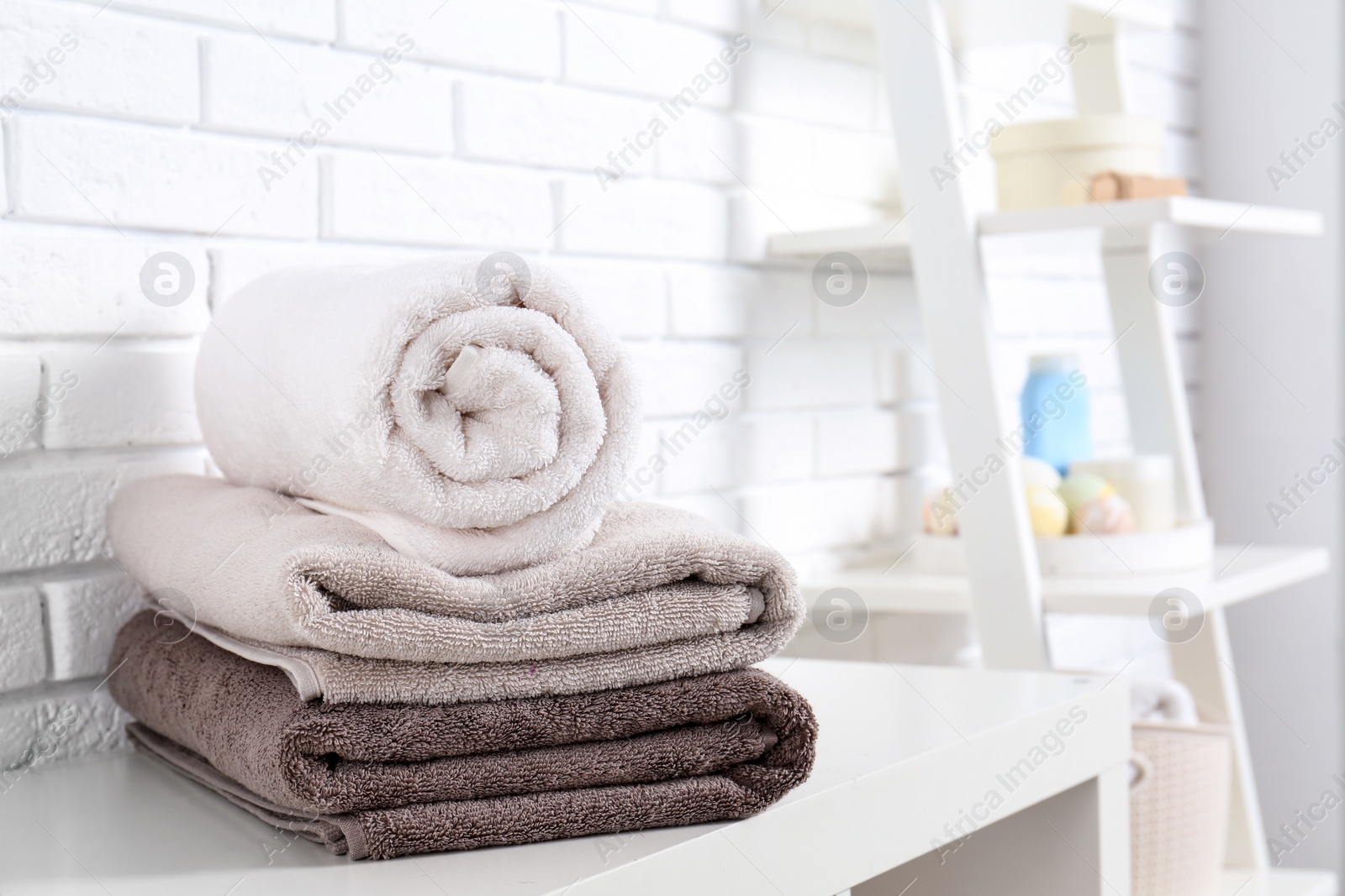 Photo of Stack of fresh towels on table in bathroom. Space for text