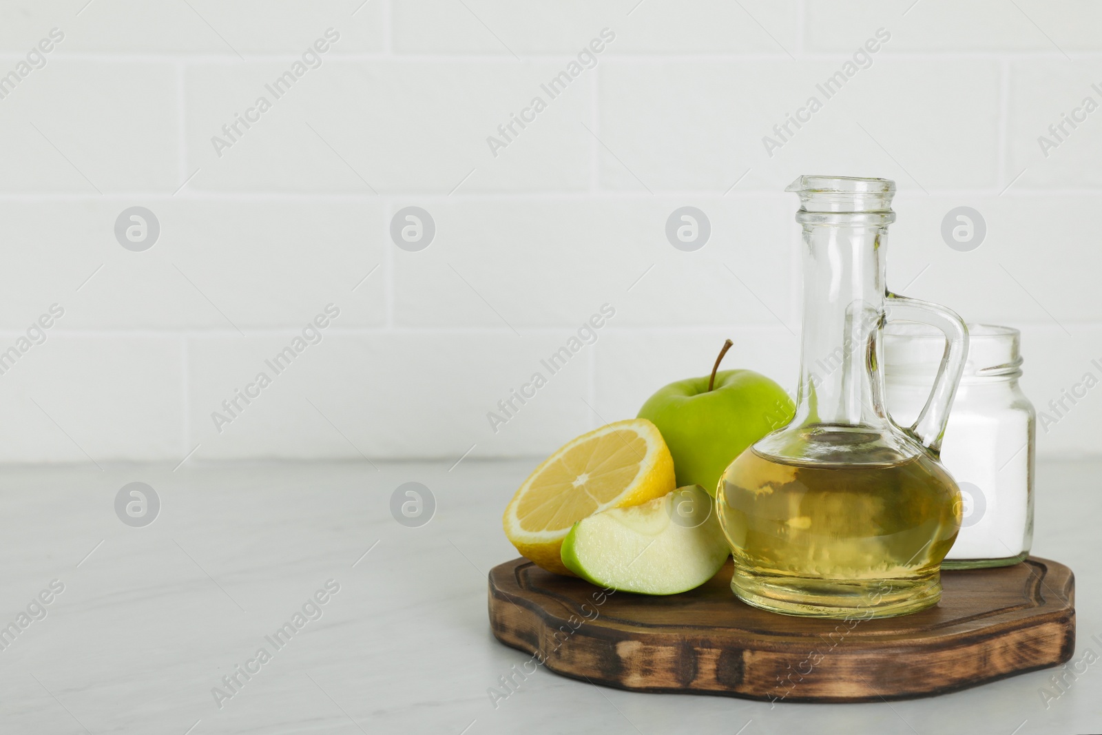 Photo of Vinegar and fresh fruits on white marble table, space for text. Eco friendly natural detergents