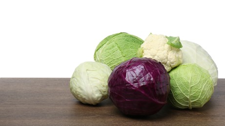 Photo of Many different fresh ripe cabbages on wooden table. Space for text