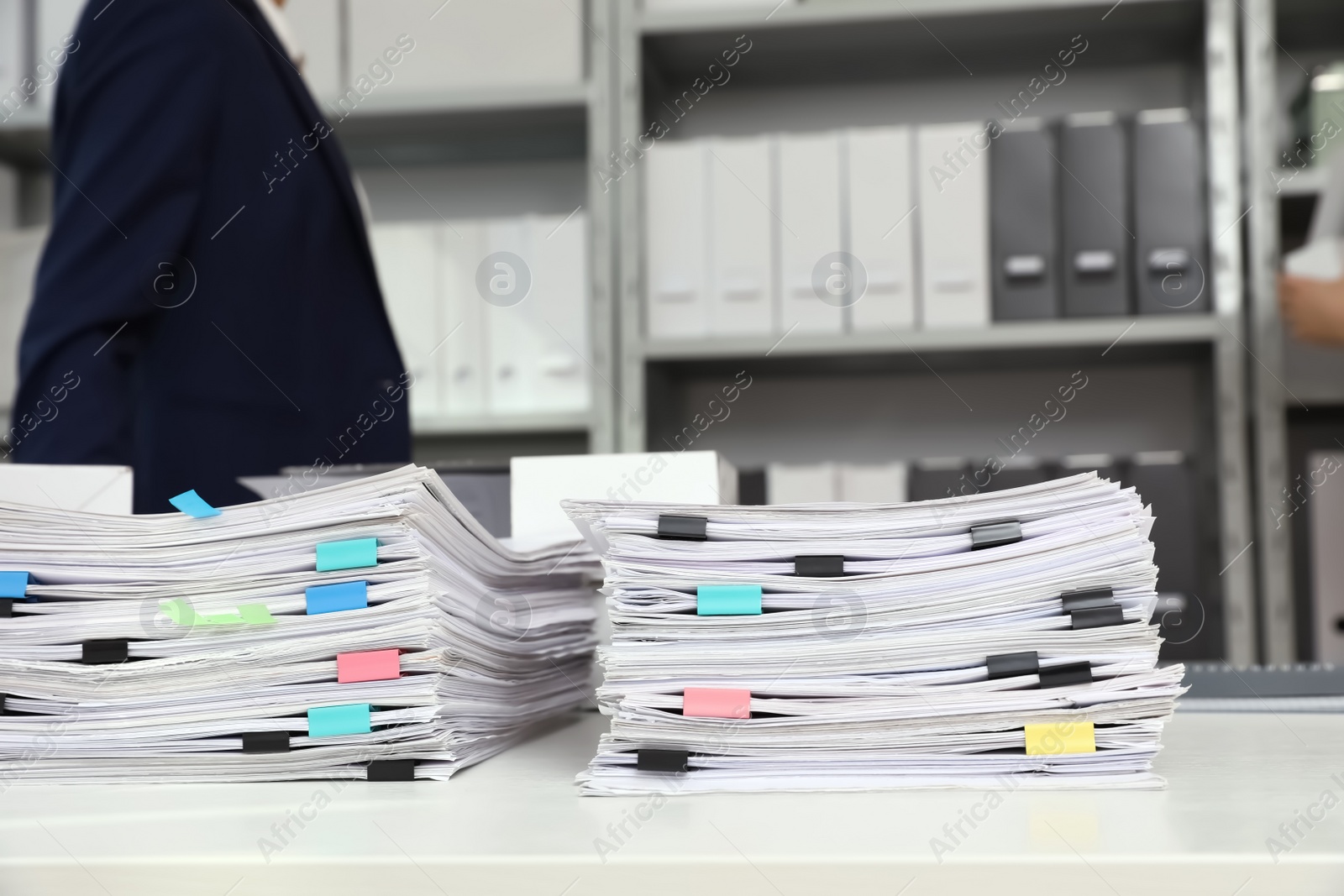 Photo of Stacks of documents with paper clips on office desk