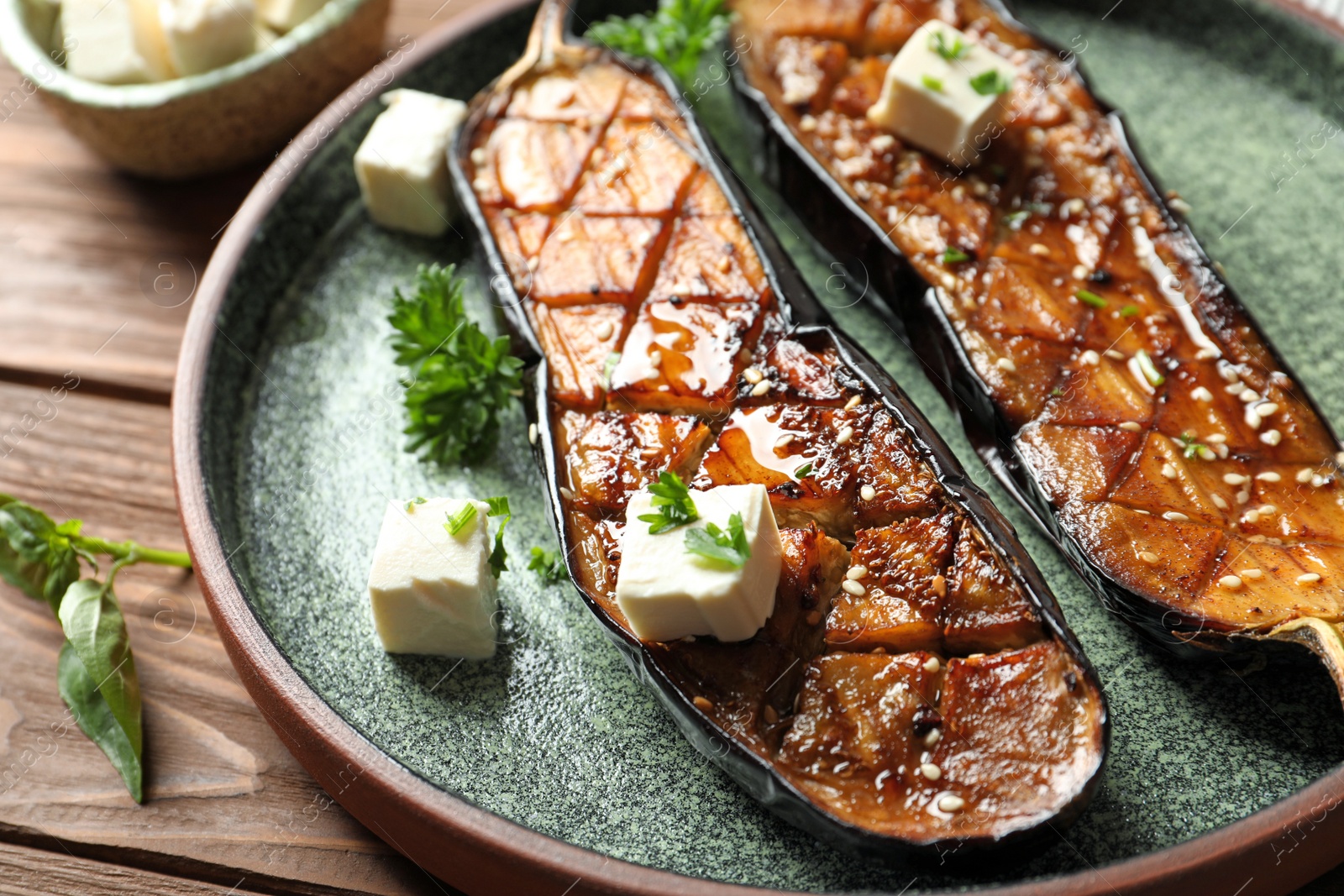 Photo of Plate with fried eggplant slices on wooden table, closeup