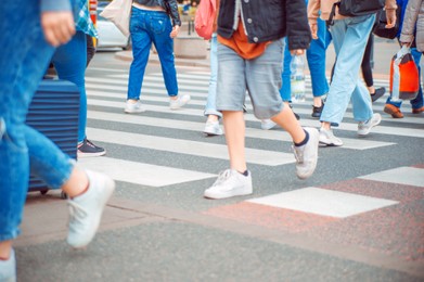 Photo of People crossing street in city, closeup view