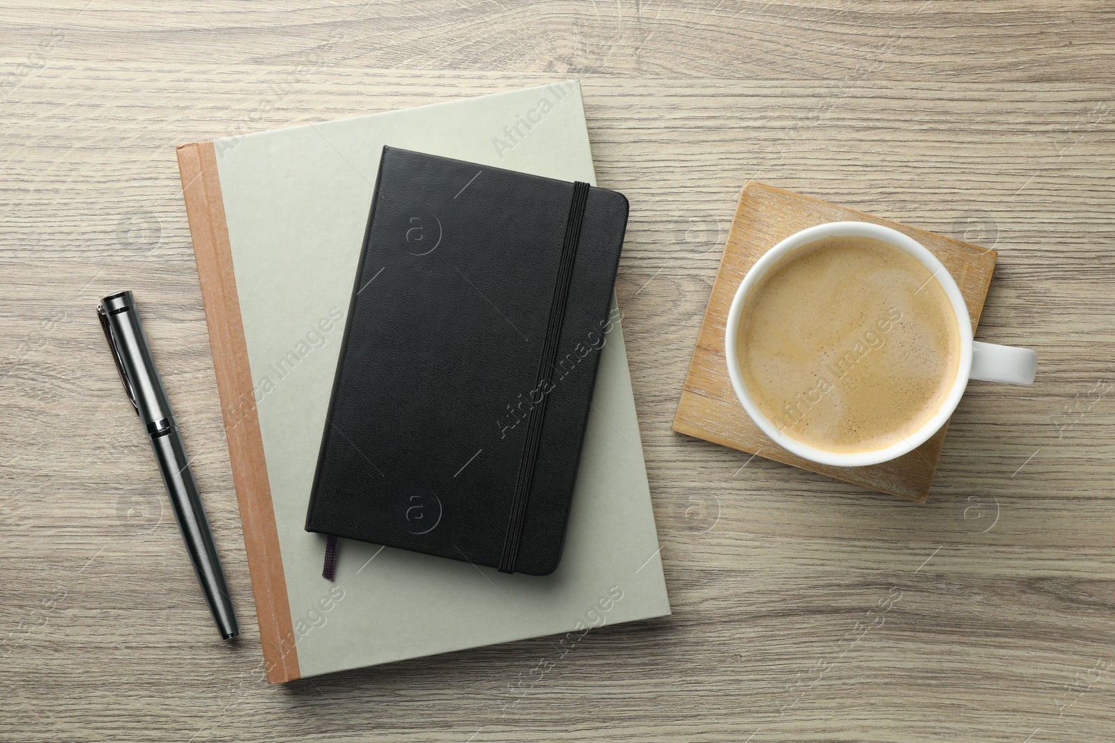 Photo of Different notebooks, pen and cup of coffee on wooden table, flat lay