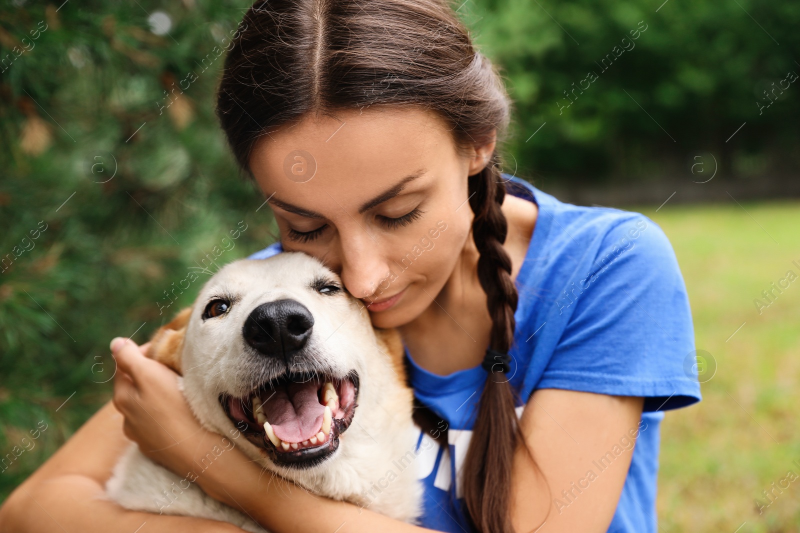 Photo of Female volunteer with homeless dog at animal shelter outdoors