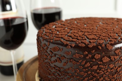 Photo of Delicious chocolate truffle cake and red wine on table, closeup