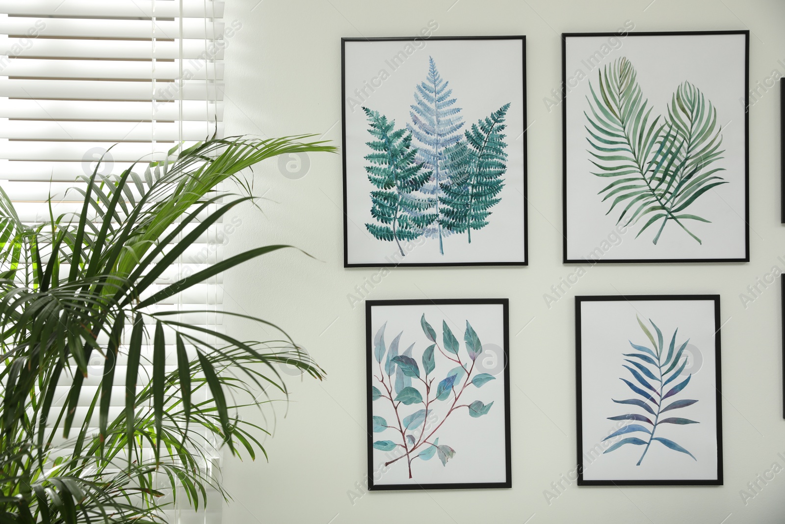 Photo of Beautiful paintings of tropical leaves on white wall in  room