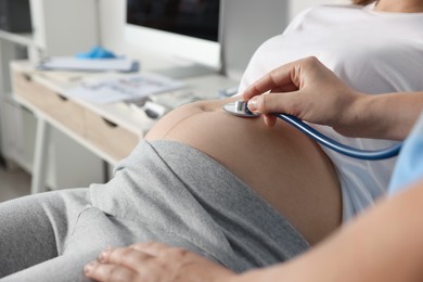 Photo of Doctor examining pregnant woman in hospital, closeup