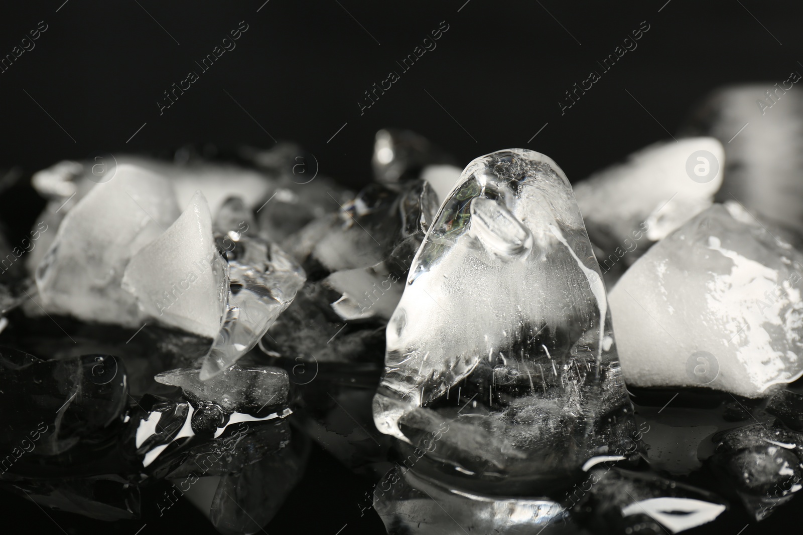 Photo of Pile of crushed ice on black mirror surface