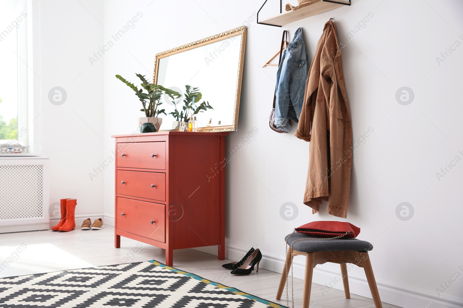 Photo of Stylish hallway interior with mirror and chest of drawers