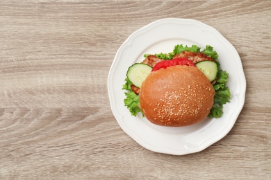 Photo of Plate with tasty sandwich on wooden table, top view. Healthy diet