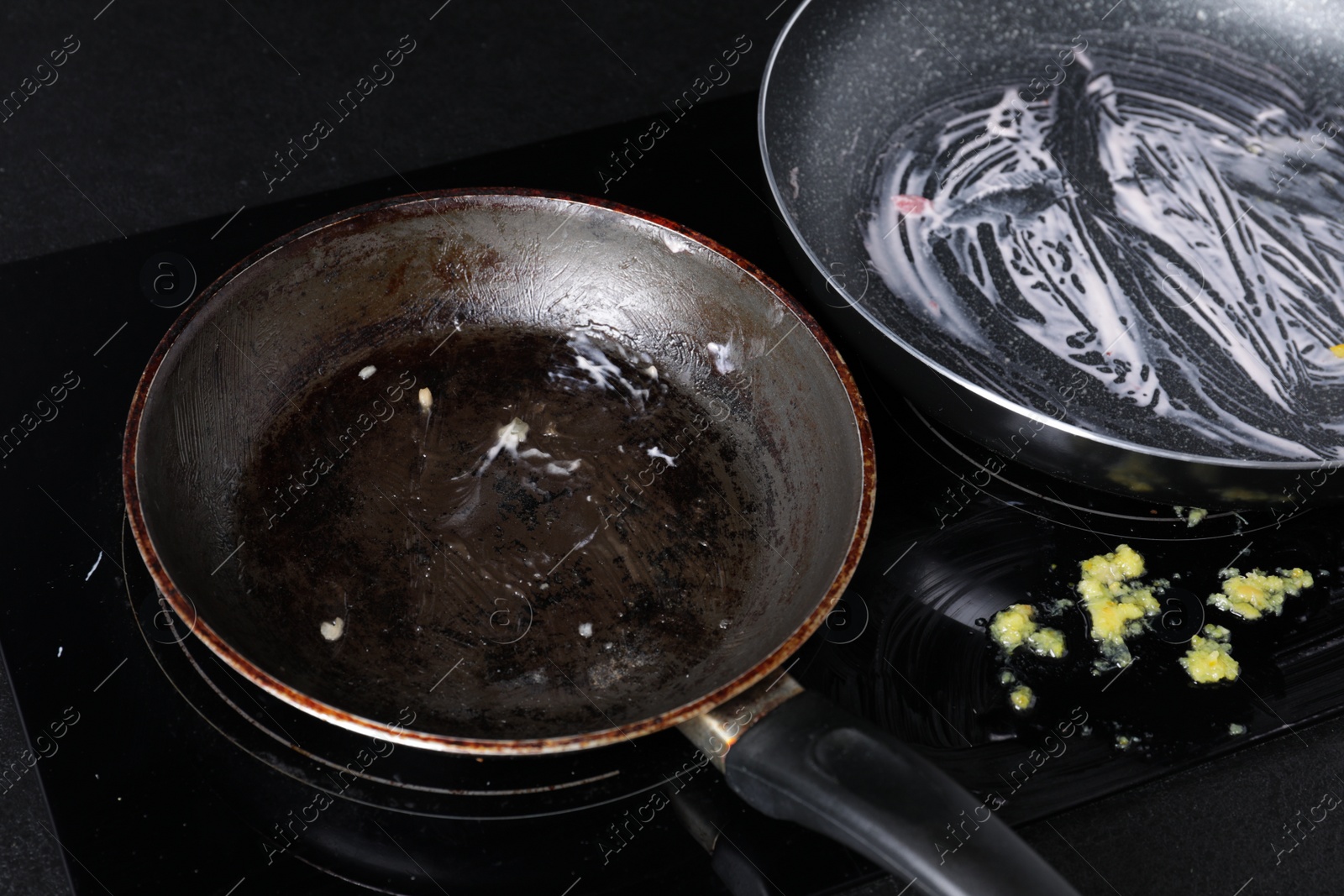 Photo of Dirty frying pans on cooktop in kitchen, closeup