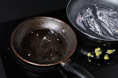 Dirty frying pans on cooktop in kitchen, closeup