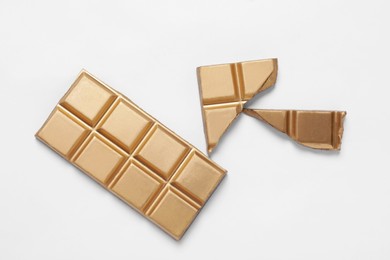 Photo of Shiny golden chocolate bar on white background, top view