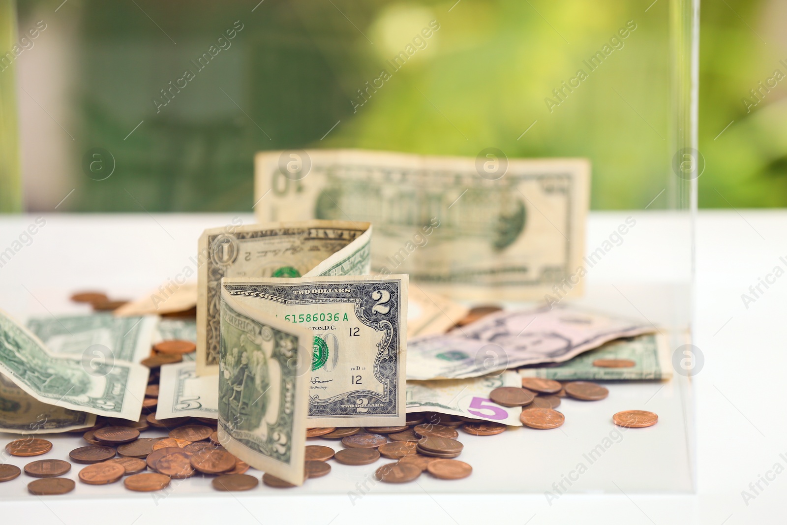 Photo of Donation box with money on table, closeup