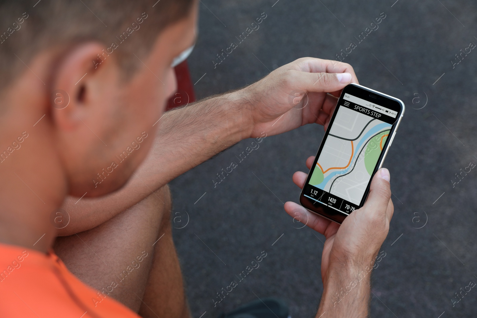 Photo of Man using fitness app on smartphone outdoors, closeup