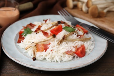 Photo of Delicious rice with bacon, mushrooms and tomatoes served on table, closeup