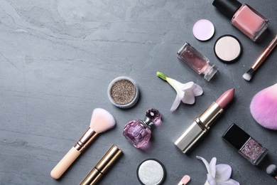 Photo of Many different makeup products and spring flowers on color background, flat lay. Space for text