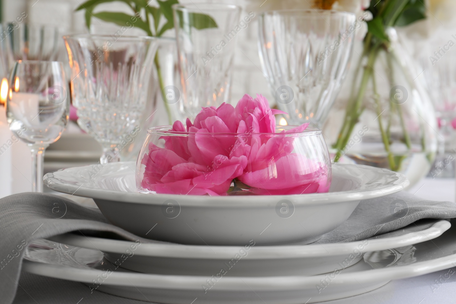Photo of Stylish table setting with beautiful peony in dining room, closeup
